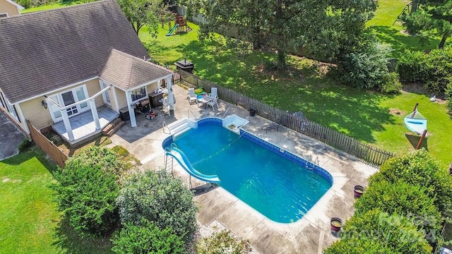 view of pool with a yard, a wooden deck, and a patio area