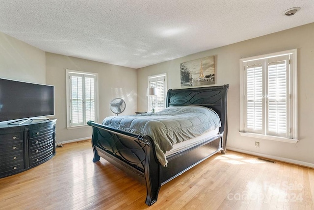 bedroom featuring light wood-type flooring and a textured ceiling