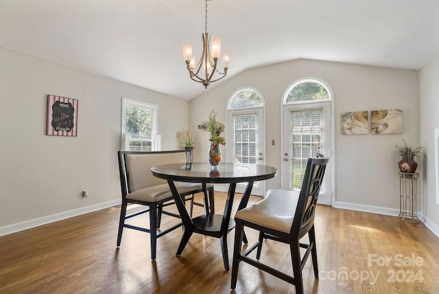 dining room with lofted ceiling, a healthy amount of sunlight, and wood-type flooring