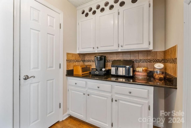 kitchen with light hardwood / wood-style flooring, white cabinets, and decorative backsplash