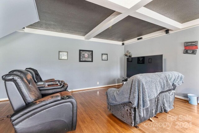 living room featuring hardwood / wood-style flooring, beam ceiling, crown molding, and a textured ceiling