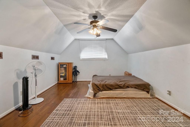 bedroom featuring lofted ceiling, ceiling fan, wood-type flooring, and a textured ceiling