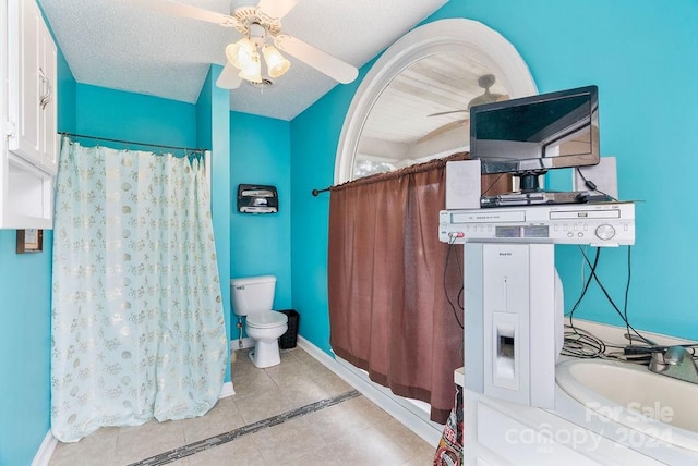 bathroom with toilet, tile patterned flooring, vanity, a textured ceiling, and ceiling fan