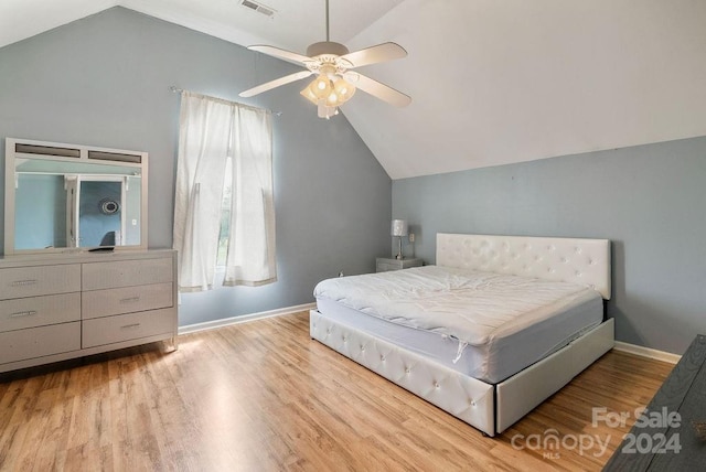 bedroom with ceiling fan, wood-type flooring, and vaulted ceiling