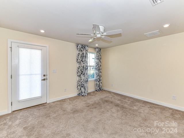 carpeted spare room with ceiling fan