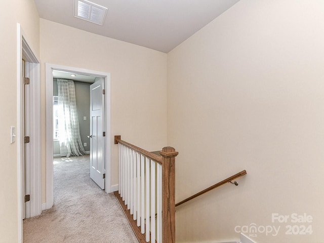 corridor featuring light colored carpet