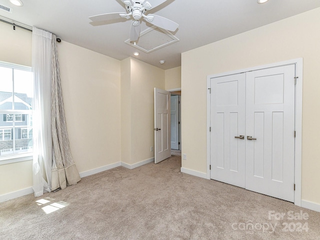 unfurnished bedroom featuring a closet, ceiling fan, and light colored carpet