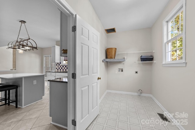 laundry area with light tile patterned flooring, washer hookup, and hookup for an electric dryer