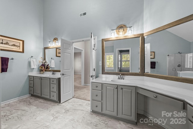 bathroom with vanity, a shower with door, and high vaulted ceiling