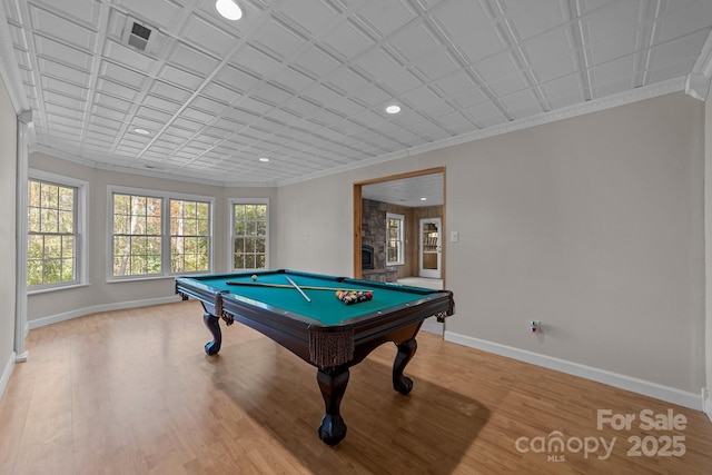 game room with a fireplace, wood-type flooring, ornamental molding, and pool table