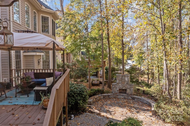 view of yard featuring an outdoor living space with a fireplace and a deck