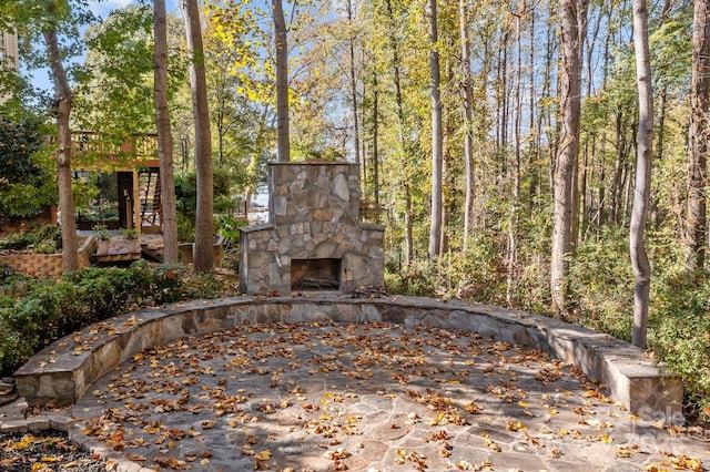 view of patio with a wooden deck and an outdoor stone fireplace