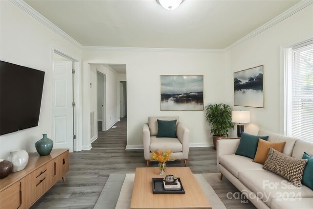 living room with dark wood-type flooring and ornamental molding