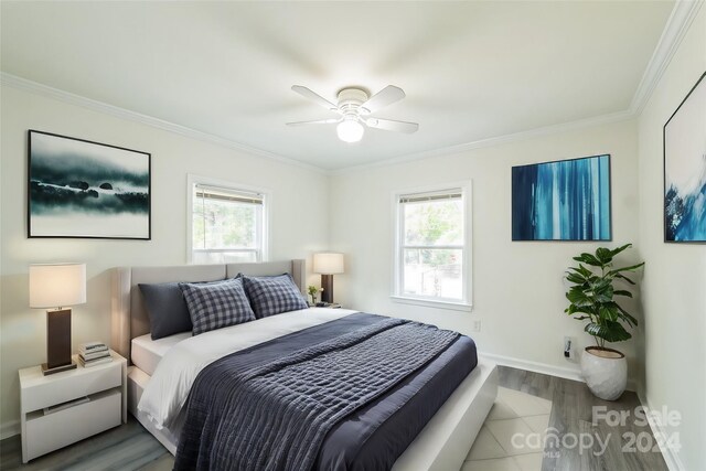 bedroom with multiple windows, ceiling fan, light hardwood / wood-style floors, and crown molding