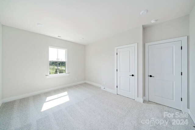 unfurnished bedroom featuring light colored carpet