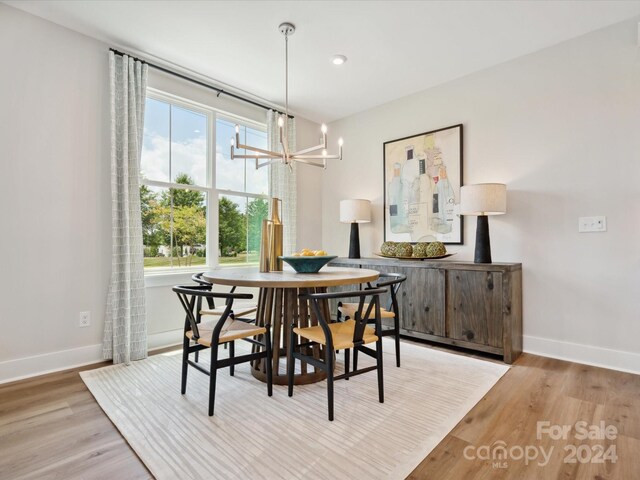 dining room with hardwood / wood-style floors and a notable chandelier