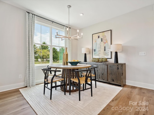 dining space with recessed lighting, light wood-type flooring, baseboards, and an inviting chandelier