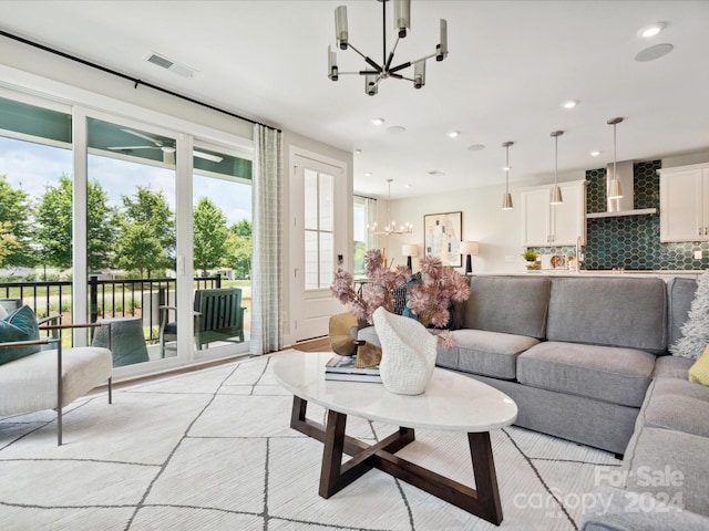 living room featuring recessed lighting, visible vents, and a chandelier