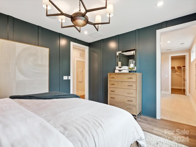 bedroom featuring light wood-type flooring, a spacious closet, and a closet