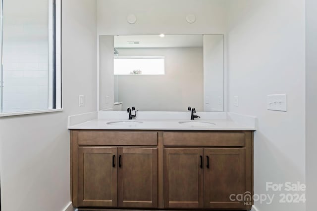 full bath featuring double vanity, visible vents, and a sink