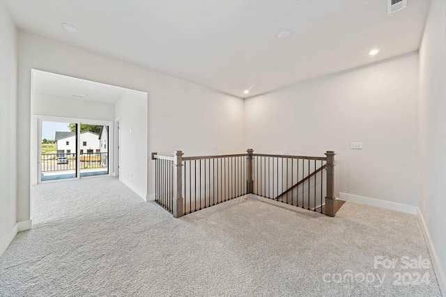 corridor with baseboards, an upstairs landing, and carpet