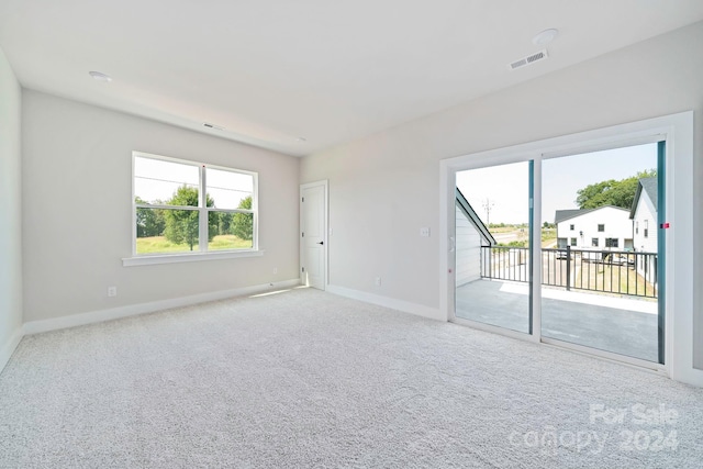 spare room with baseboards, visible vents, and carpet floors