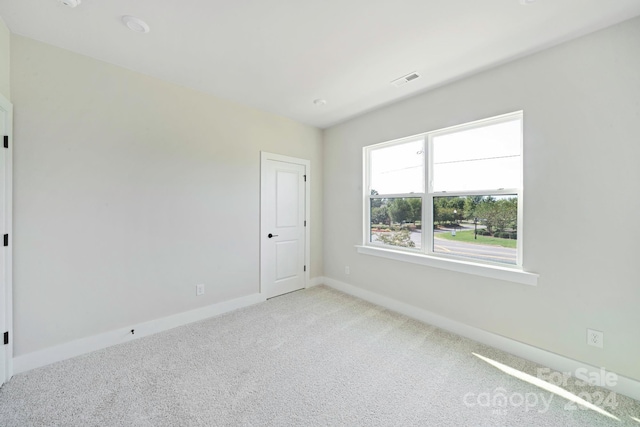 unfurnished room featuring visible vents, baseboards, and carpet flooring