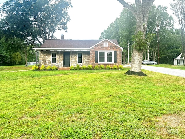 single story home with covered porch and a front yard