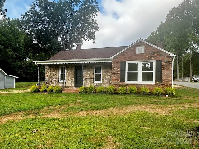 single story home featuring a porch and a front lawn