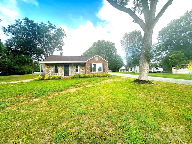 ranch-style house with a front yard and covered porch