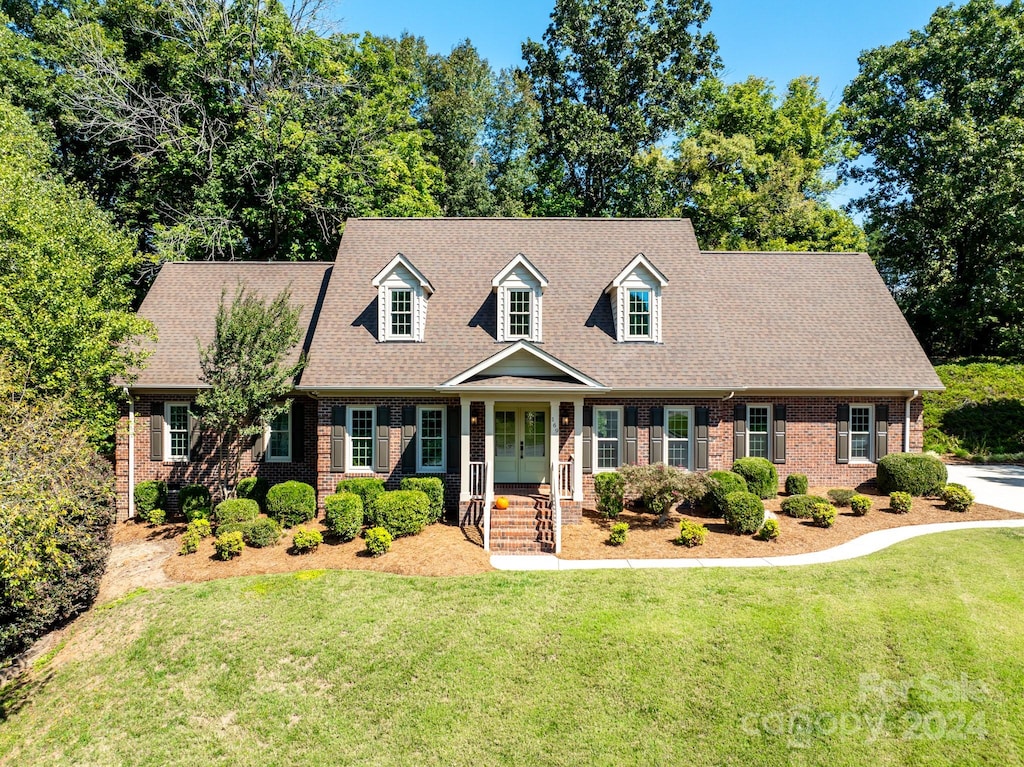 new england style home with a front lawn and covered porch