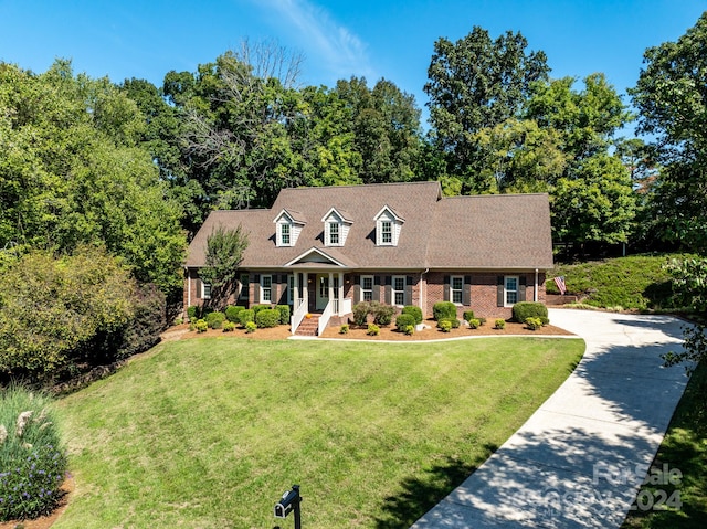 new england style home featuring a front lawn and a porch