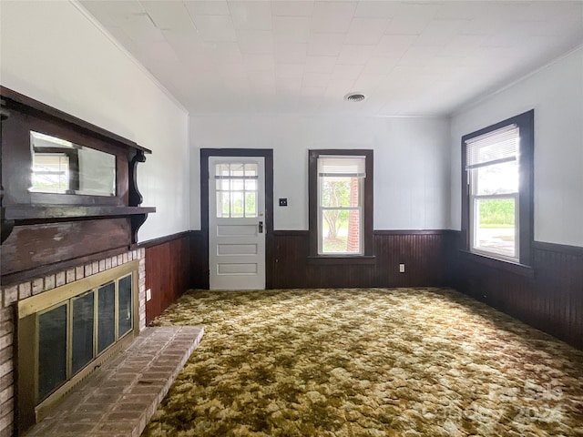 foyer featuring ornamental molding, plenty of natural light, and wood walls