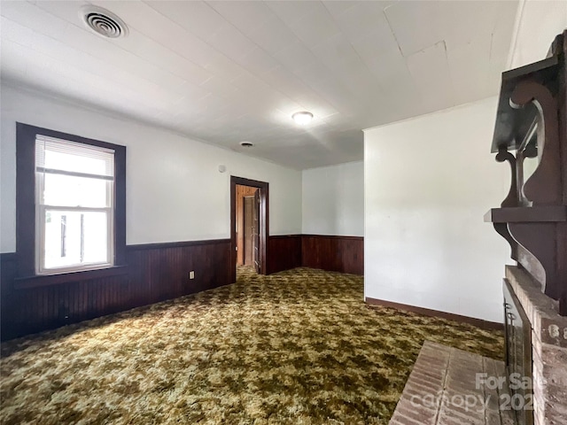 carpeted empty room with wooden walls