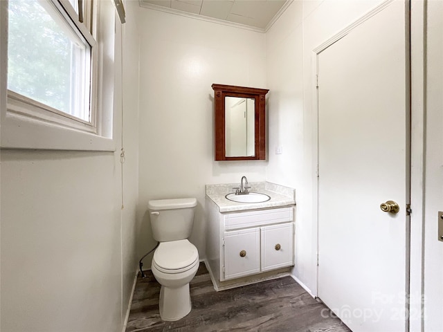 bathroom featuring crown molding, toilet, vanity, and wood-type flooring