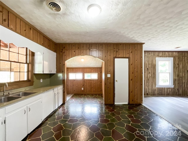 kitchen with white cabinets and wooden walls