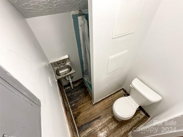 bathroom featuring a shower with shower curtain, hardwood / wood-style floors, sink, and toilet