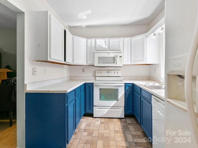 kitchen featuring white appliances, blue cabinetry, sink, and white cabinets