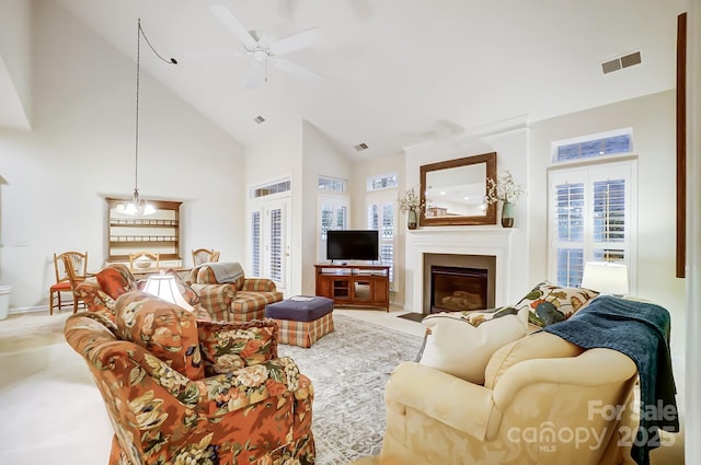 living room with ceiling fan with notable chandelier, high vaulted ceiling, and a wealth of natural light