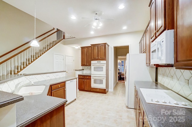 kitchen featuring tasteful backsplash, white appliances, ceiling fan, sink, and hanging light fixtures