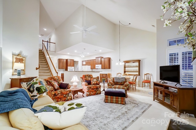 living room with high vaulted ceiling and ceiling fan with notable chandelier