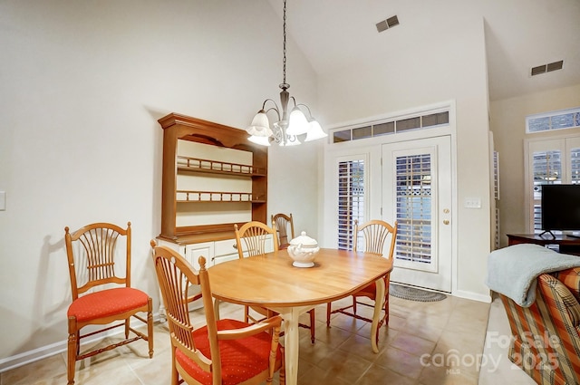 dining area featuring light tile patterned floors, a high ceiling, and a notable chandelier