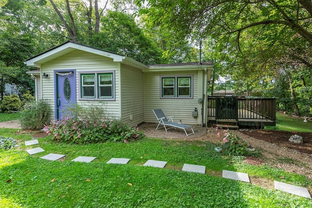 back of house with a wooden deck and a yard