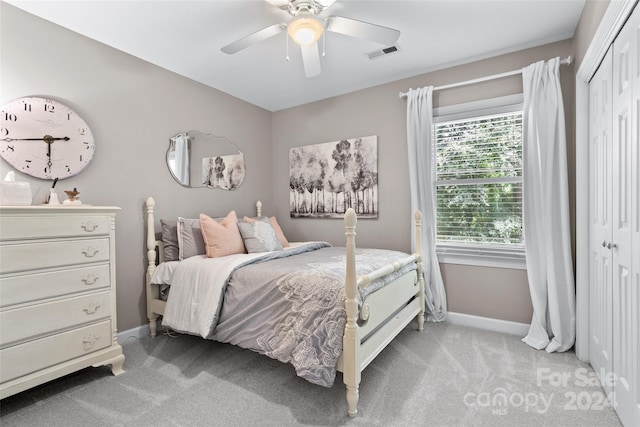 carpeted bedroom featuring ceiling fan and a closet