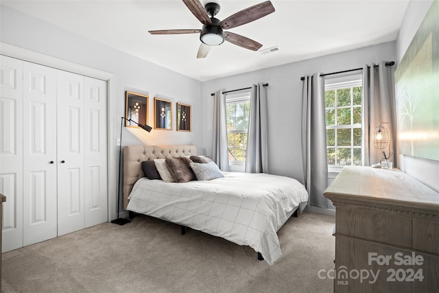 bedroom with light carpet, a closet, and ceiling fan