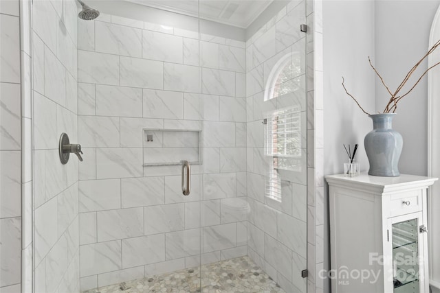 bathroom with ornamental molding and an enclosed shower