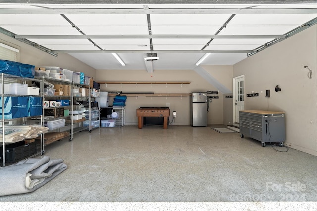 garage featuring a garage door opener and stainless steel refrigerator