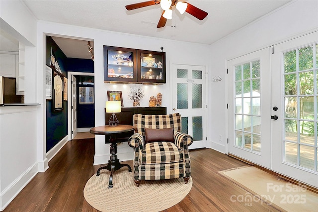 living area featuring a textured ceiling, ceiling fan, dark wood-type flooring, and french doors