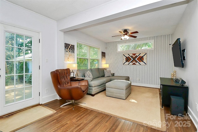 living room featuring wood-type flooring, a textured ceiling, and ceiling fan