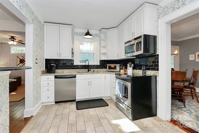 kitchen featuring white cabinets, appliances with stainless steel finishes, tasteful backsplash, and sink